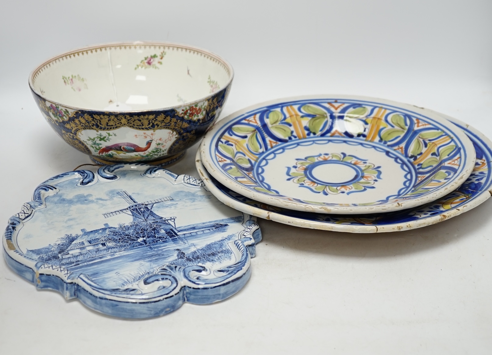A Delft blue and white plaque, two continental tin-glazed dishes, one signed V.M.D, and a Booths scale-blue bowl, largest 35cm in diameter. Condition - largest dish poor, others fair